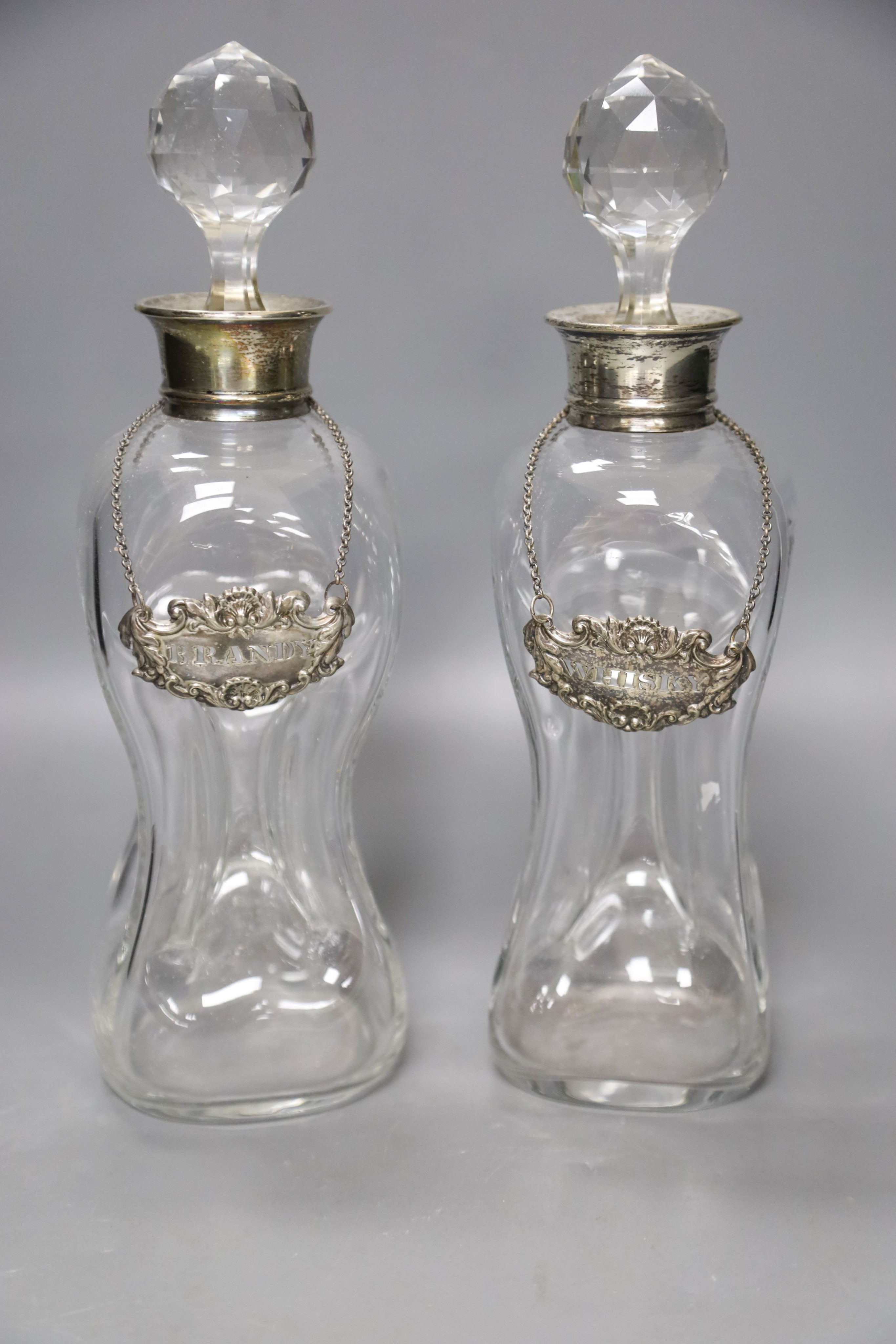 A pair of Regency small cut glass decanters, a pair of silver-mounted 'dimple' decanters, another pair of decanters and two other decanters.